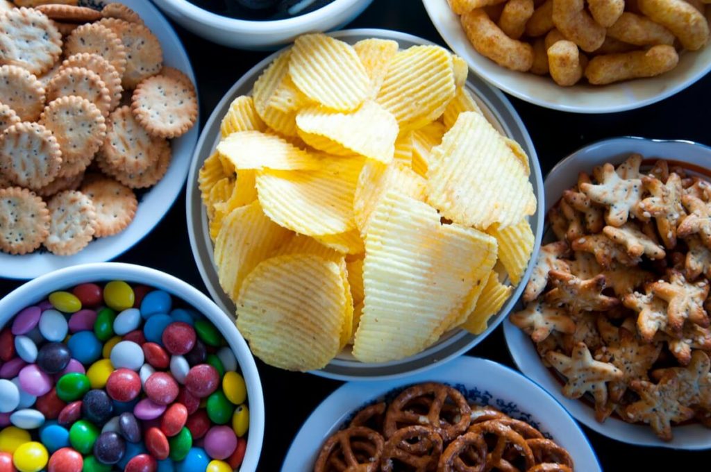 Different sweet and savoury snacks laid out in bowls on a table