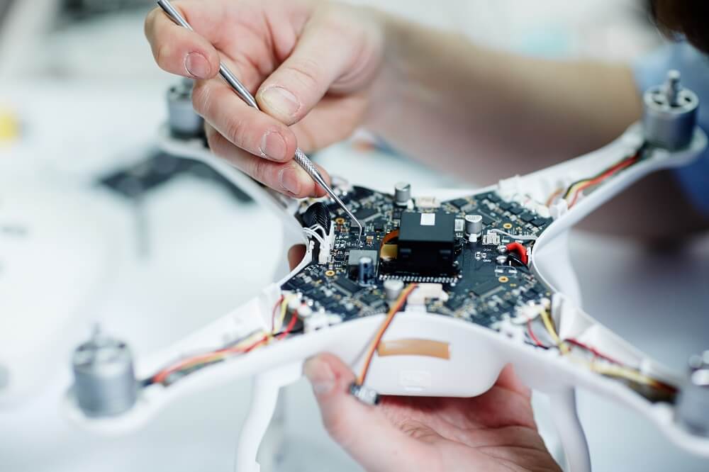 Man fixing a circuit board of a drone